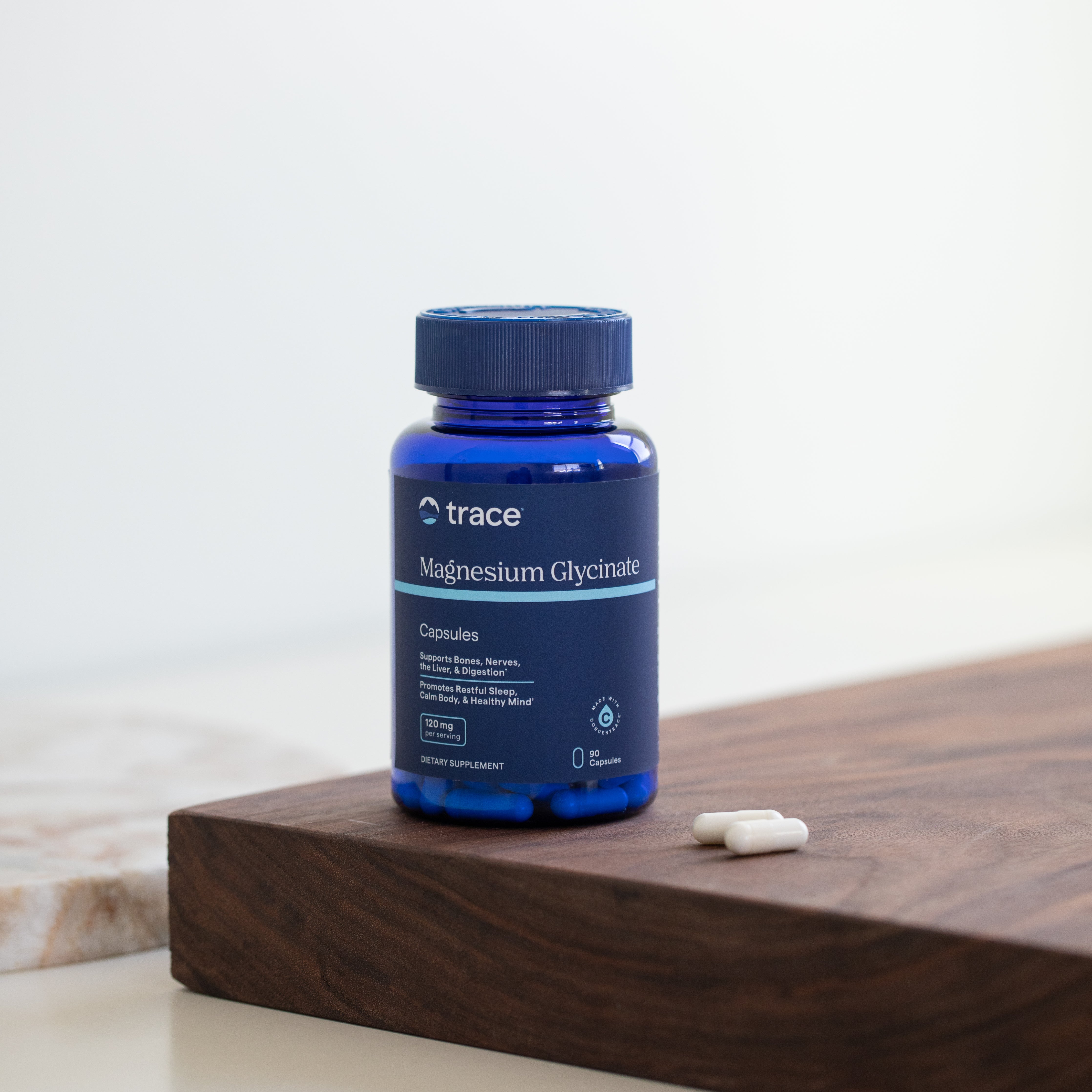 Trace Minerals magnio glicinato 90 kaps. pakuotė ant stalo su kapsulėmis